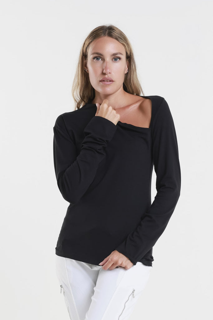 Woman wearing a black long-sleeve top and white pants on a white background