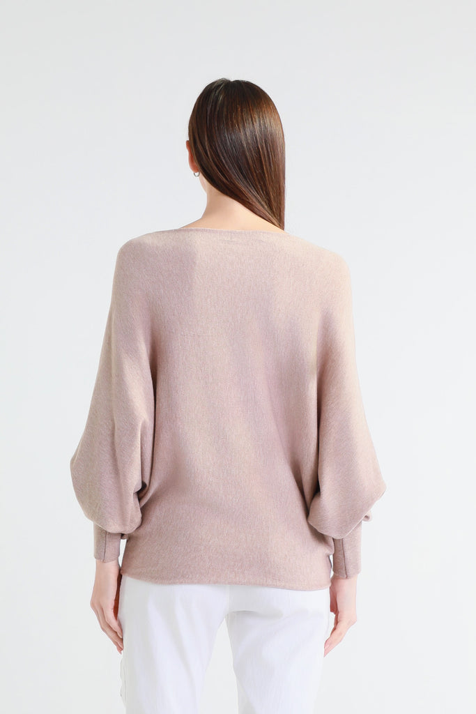 Woman wearing a beige sweater on a white background