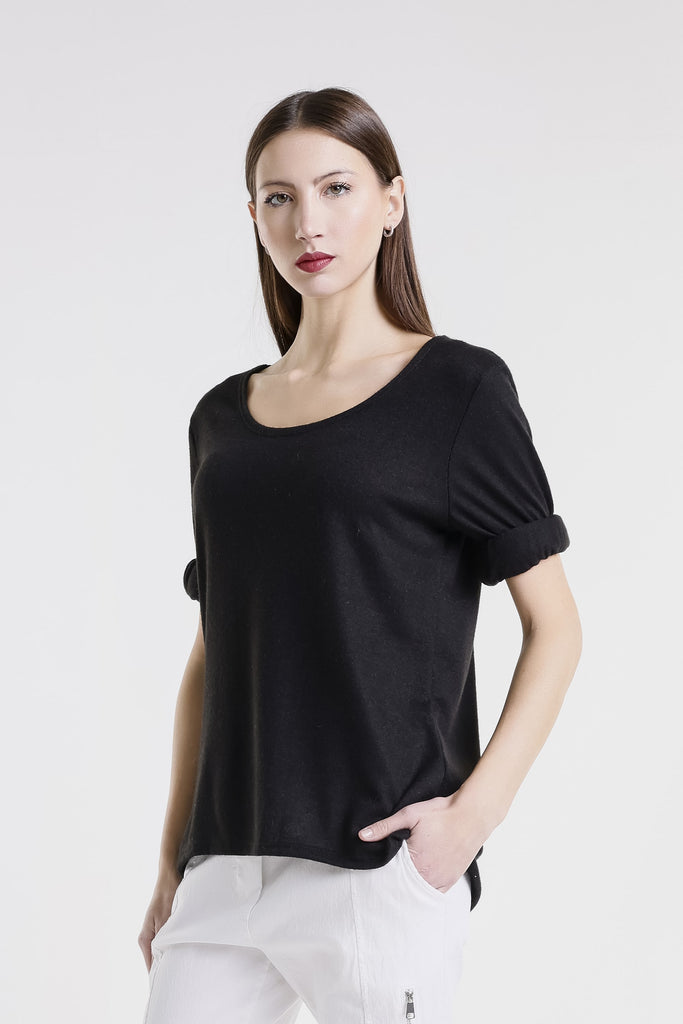 Woman wearing a black top and white pants on a white background