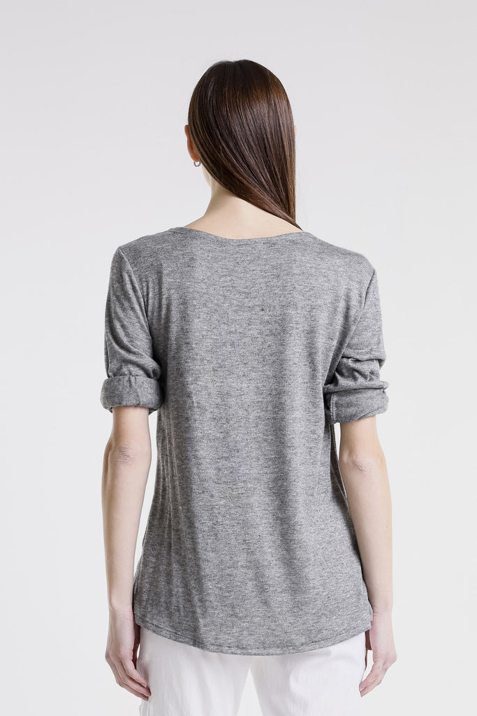 Person wearing a gray long-sleeve top on a white background