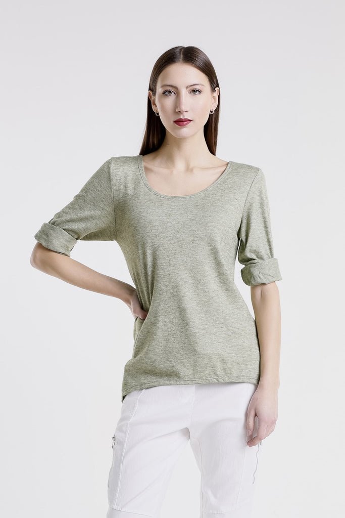 Woman wearing a green shirt and white pants on a white background