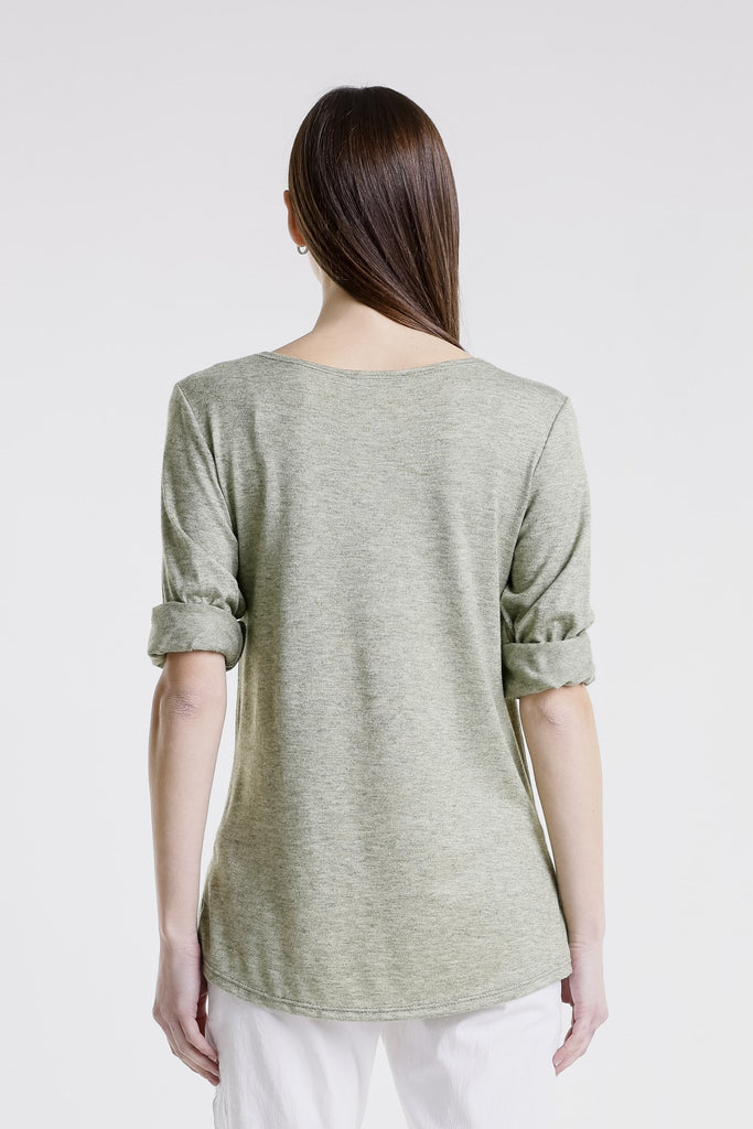Woman wearing a light green shirt with rolled-up sleeves on a white background