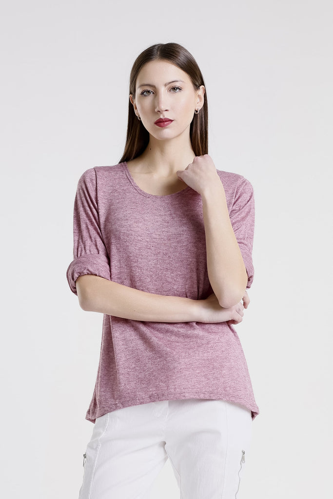 Woman wearing a pink top and white pants on a white background