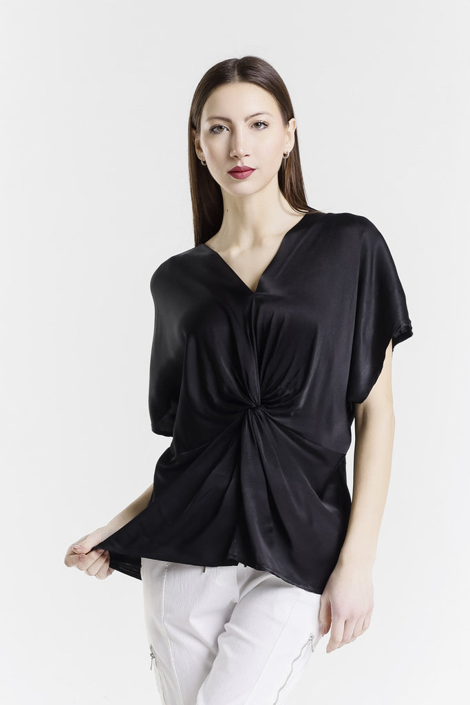 Woman wearing a black top with a knot detail on a white background