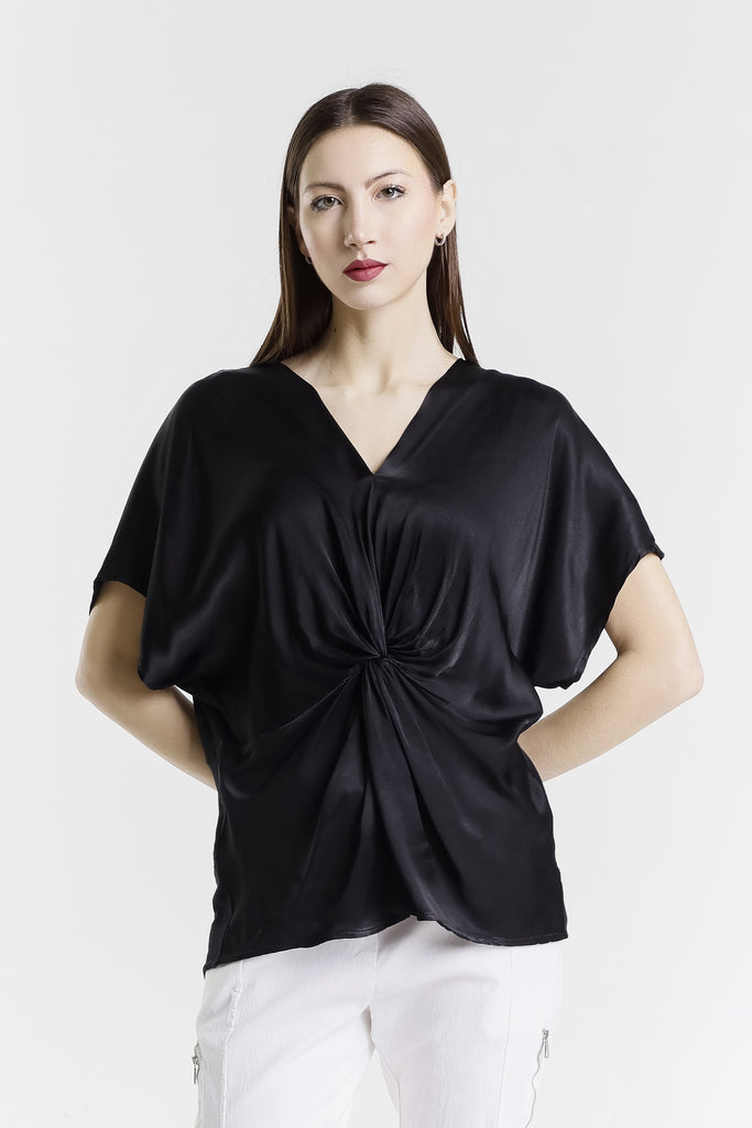 Woman wearing a black top with a knot detail on a white background