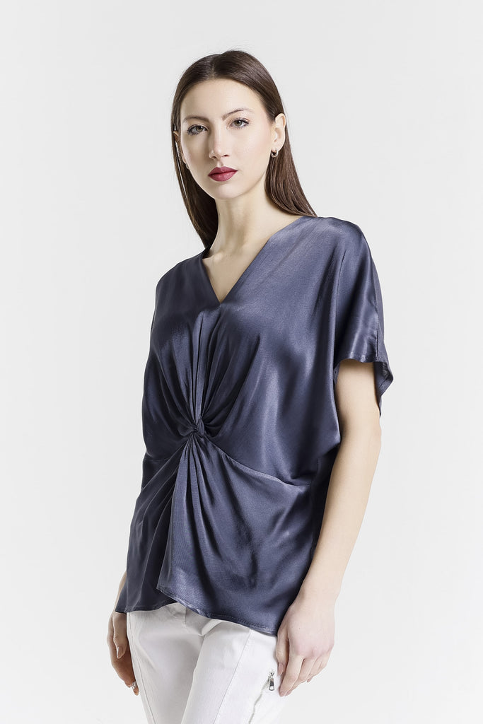 Woman wearing a blue satin top with a white background