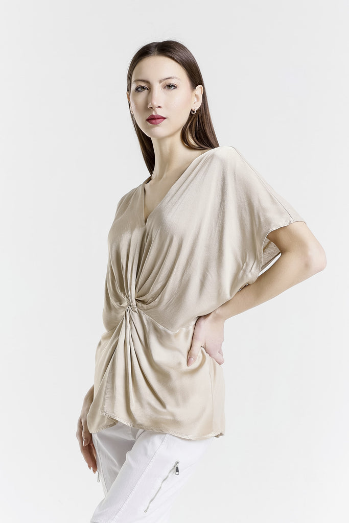 Woman wearing a beige top with a white background