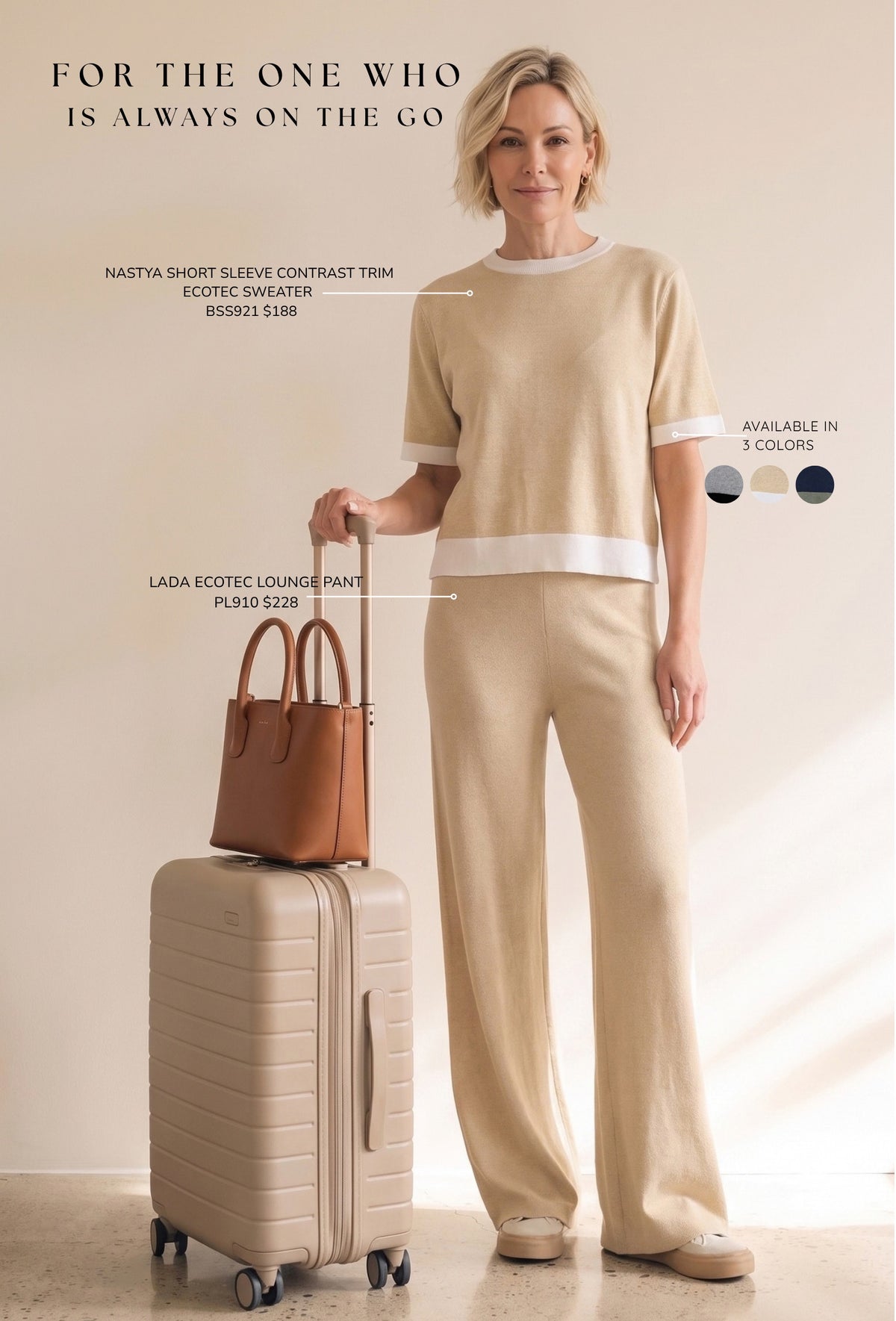 A woman stands indoors wearing a beige knit two-piece outfit with white contrast trim, holding the handle of a beige rolling suitcase beside a brown handbag. Text on the image identifies the sweater as Natasha short sleeve contrast trim Ecotec Sweater and the pants as Lada ecotex lounge pants.