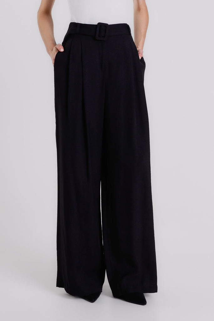 Black wide-leg pants worn by a person on a white background