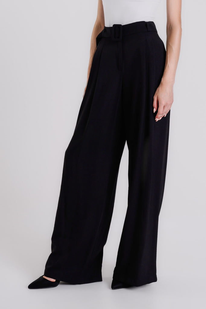 Black wide-leg pants worn by a person on a white background