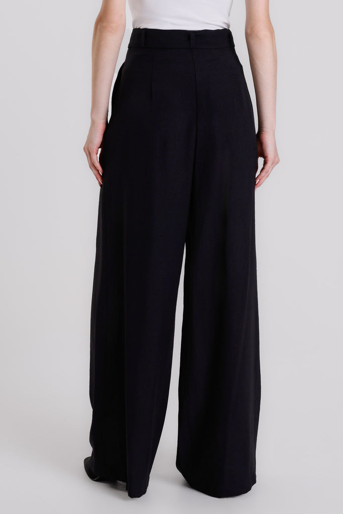 Black wide-leg pants worn by a person on a white background