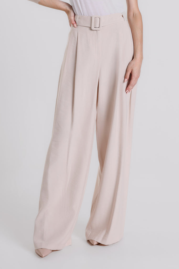 Beige wide-leg pants worn by a person on a white background