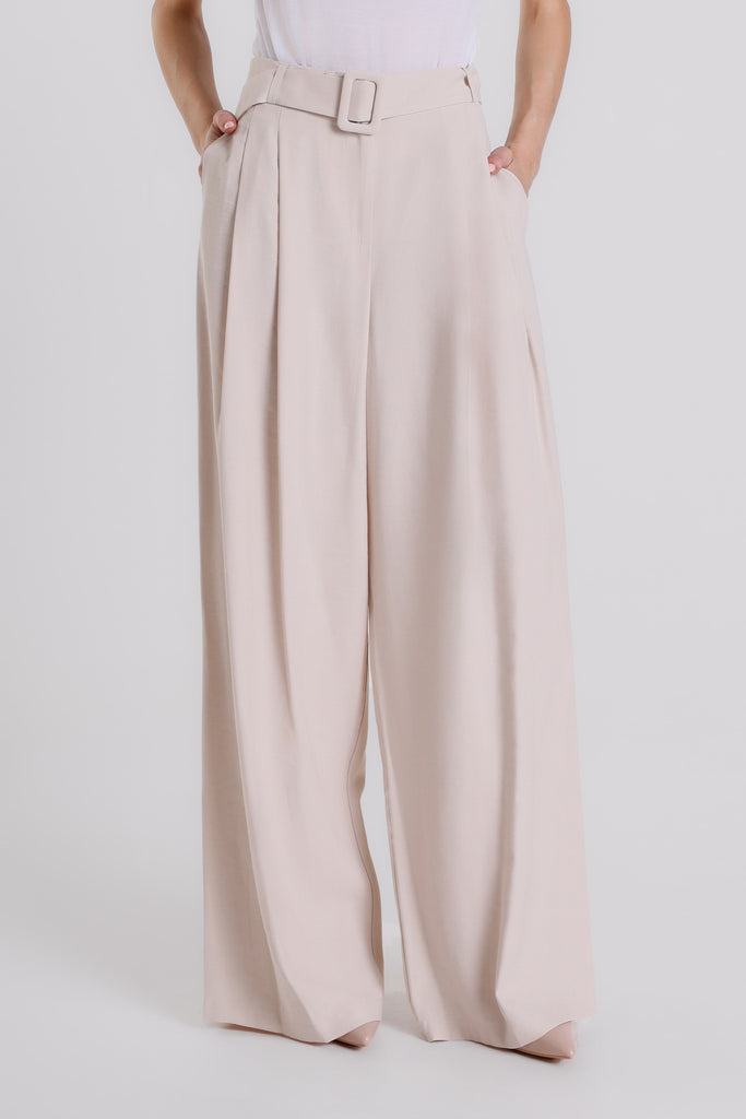 Beige wide-leg pants worn by a person on a white background