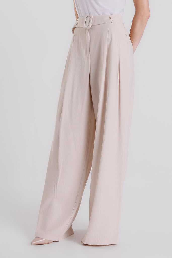 Beige wide-leg pants worn by a person on a white background