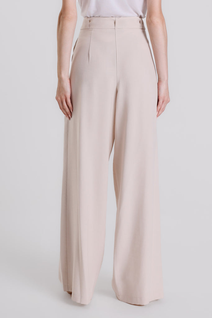 Beige wide-leg pants worn by a person on a white background